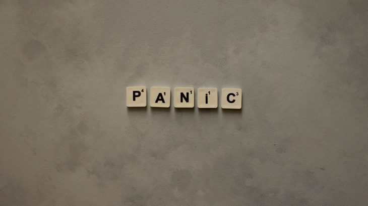 Scrabble tiles forming the word 'Panic' on a simple neutral background, symbolizing anxiety.